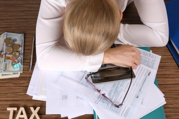Tired businesswoman of calculating expenses at desk in office