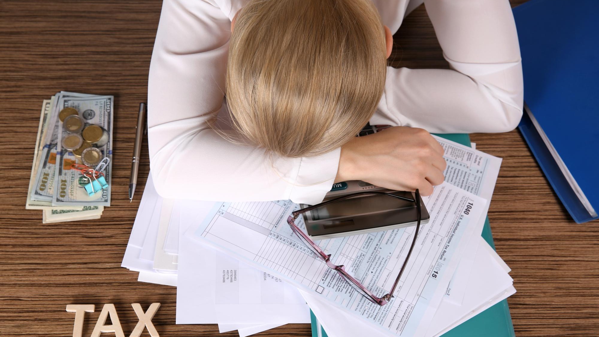 Tired businesswoman of calculating expenses at desk in office