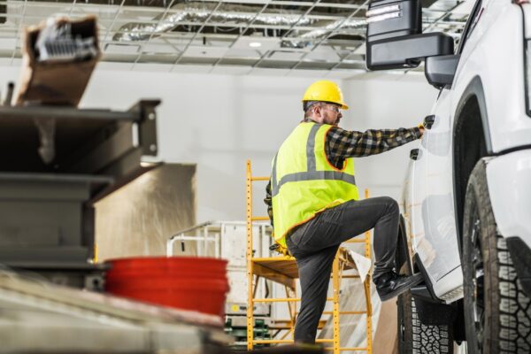Caucasian Construction Worker Wearing Hardhat Loading His Pickup Cargo Bed