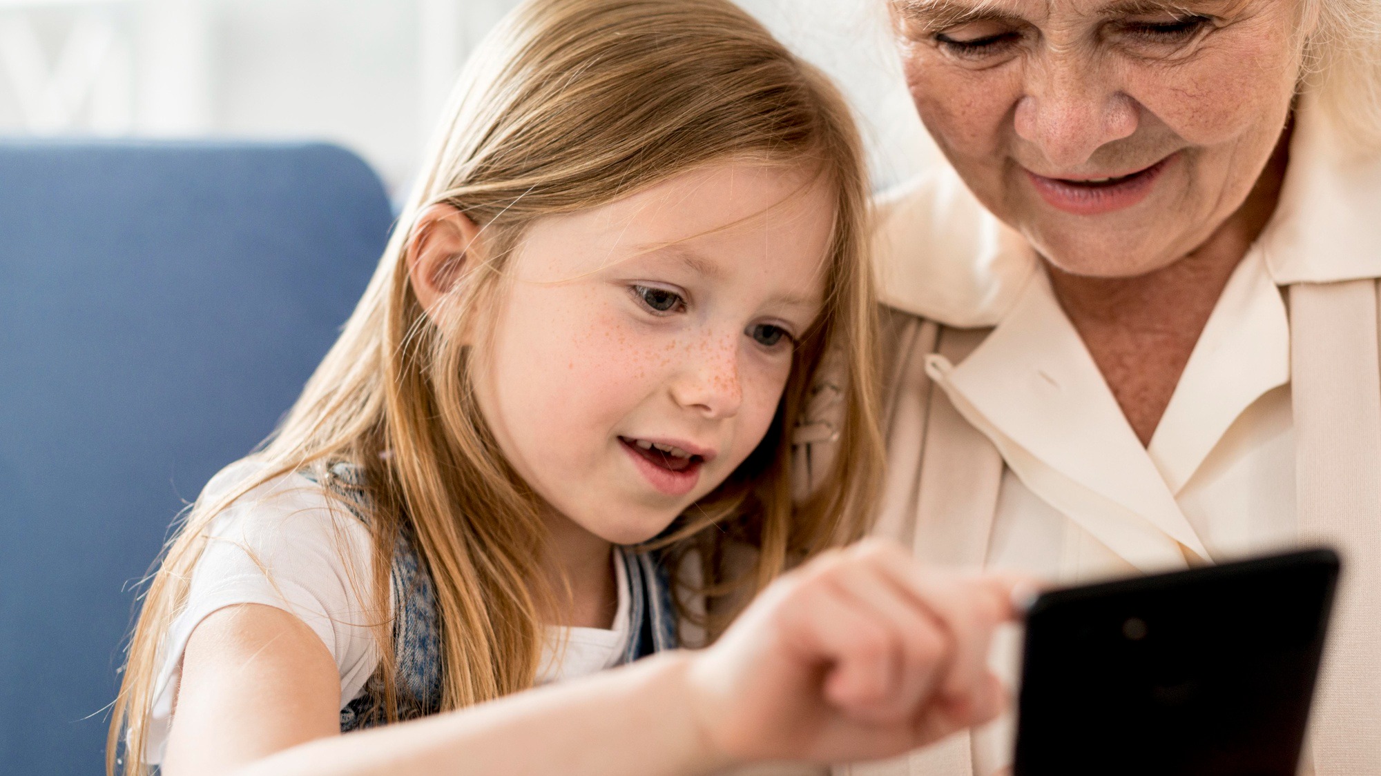 Grandmother and girl looking at mobile