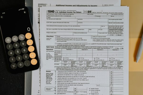 Tax forms and calculator on a desk.