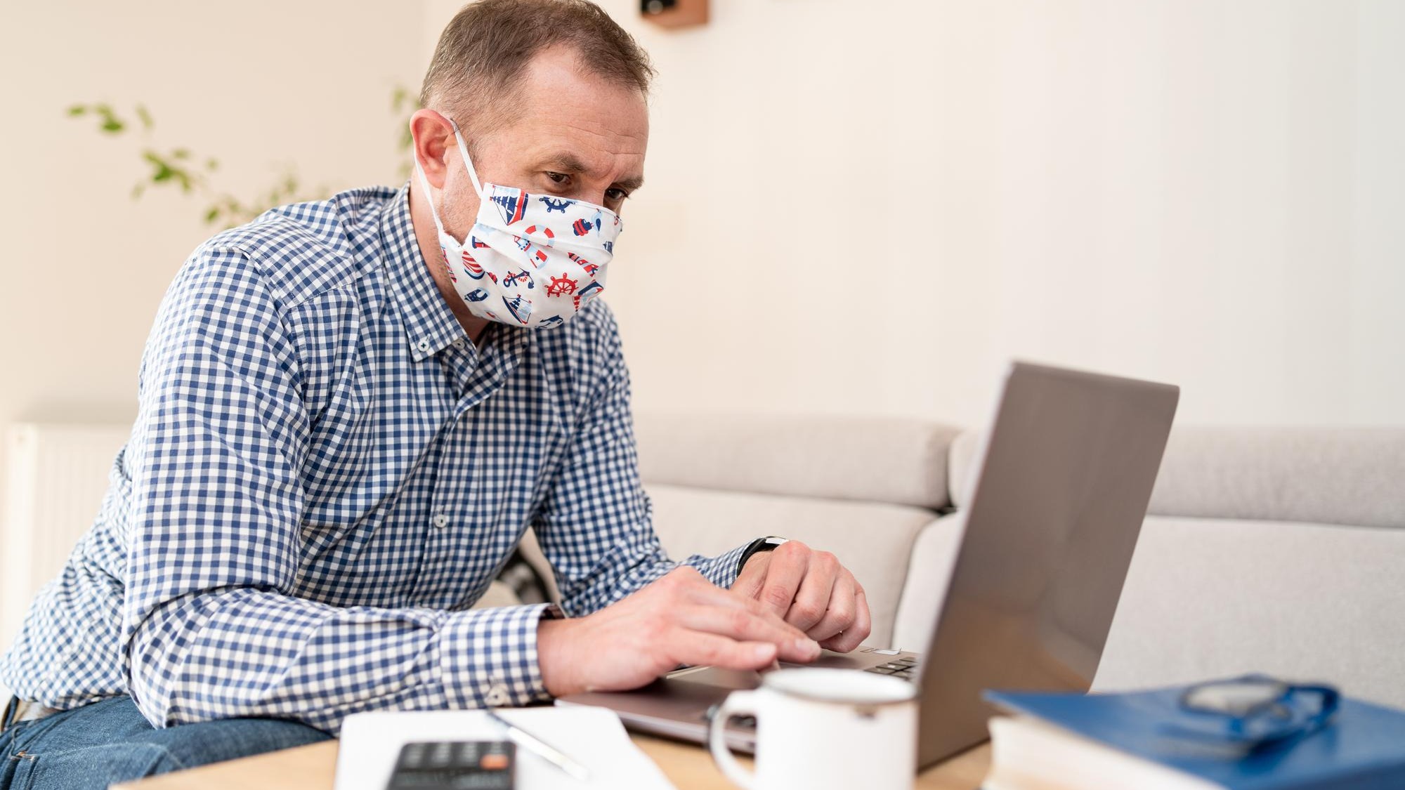 Portrait of pensive young businessman with surgical medical mask in shirt