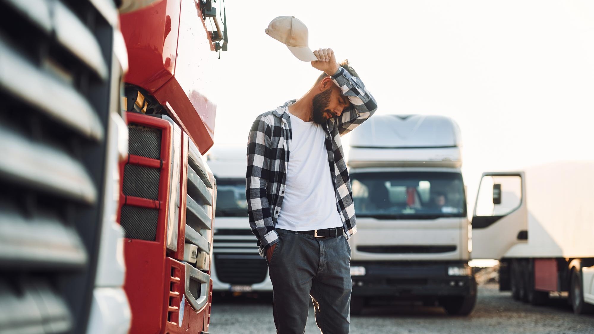 Tired walking outside Young truck driver is with his vehicle at daytime