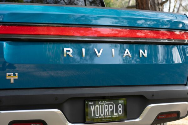 the back end of a blue car with a license plate