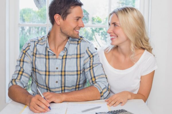 Couple with financial documents and calculator at home