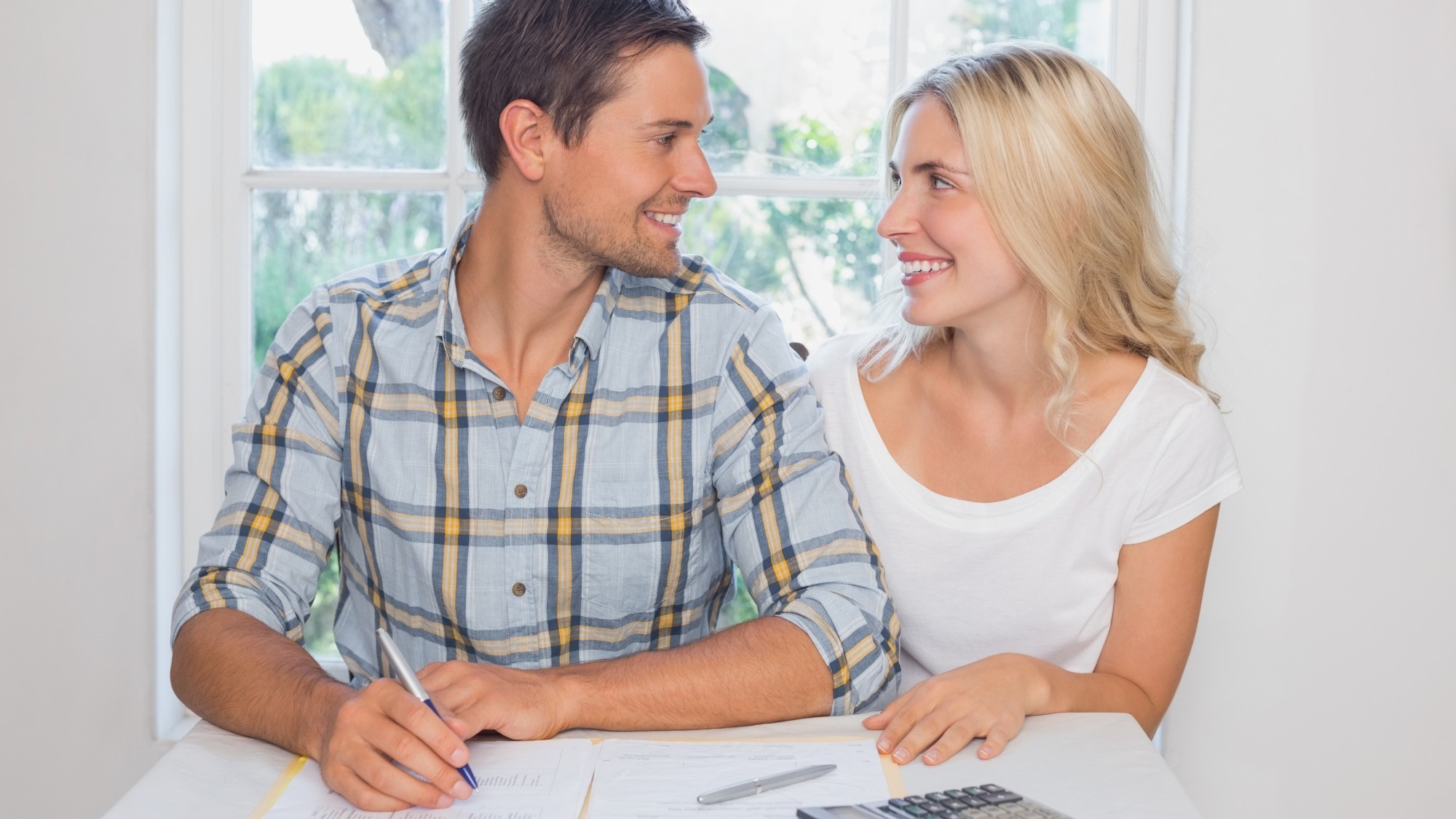 Couple with financial documents and calculator at home