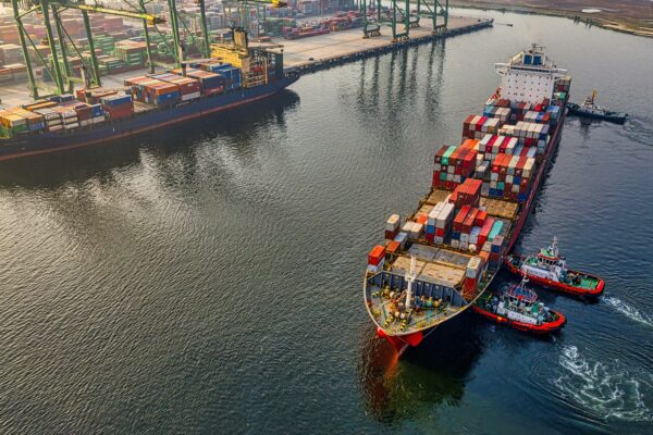 red and blue cargo ship on body of water during daytime