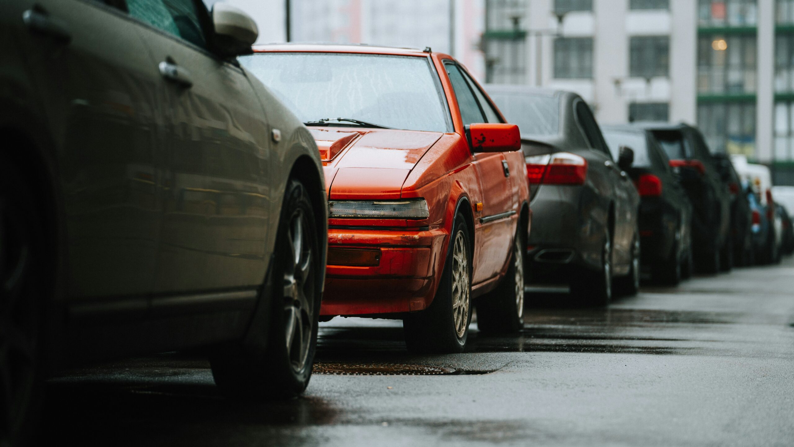 a row of parked cars on a wet street