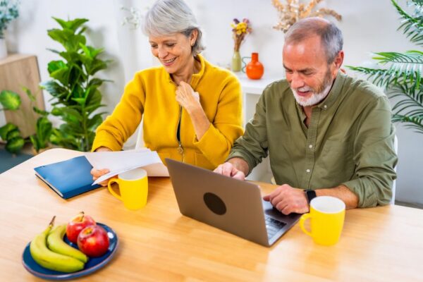Happy senior couple working on personal financial bills at home