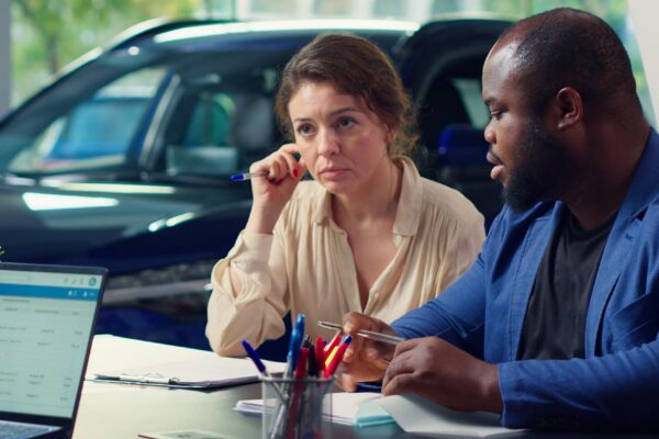 Customers in dealership completing necessary car payment paperwork