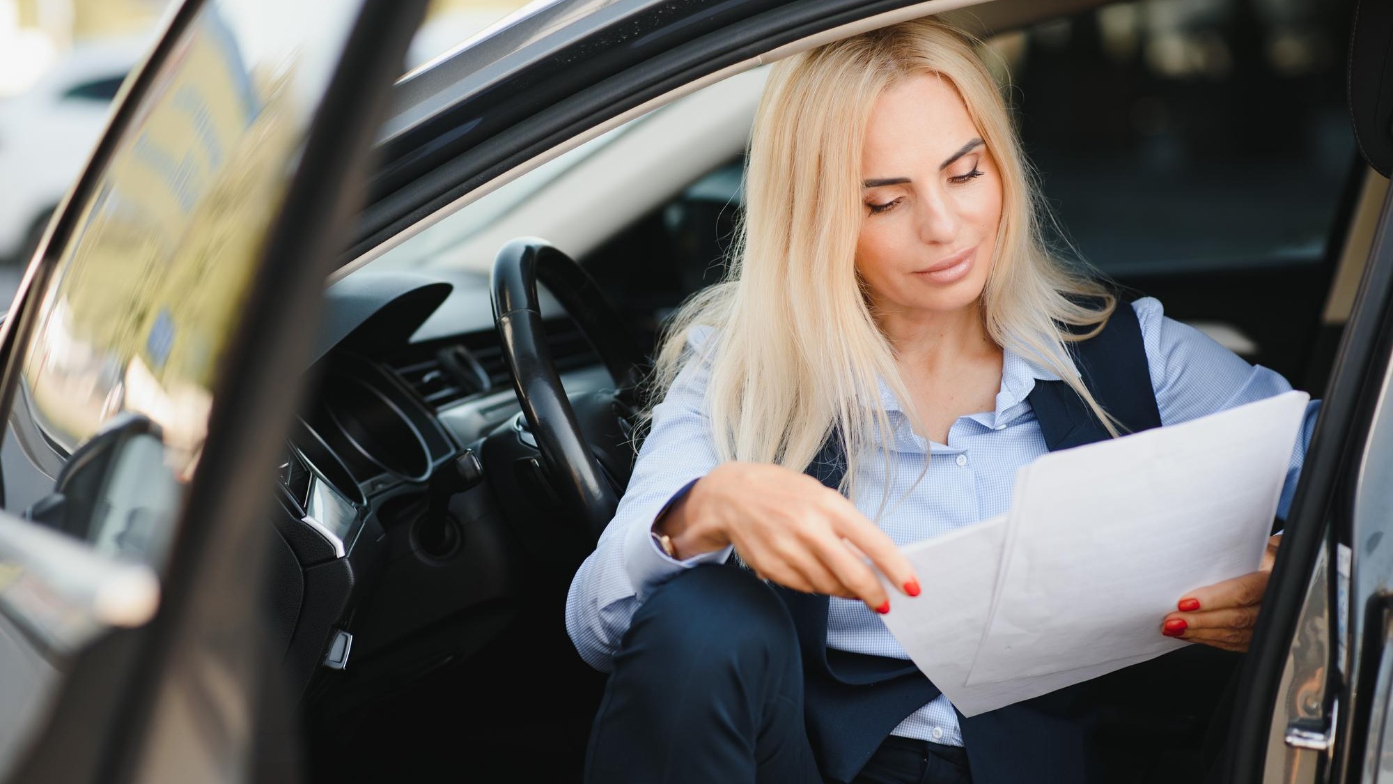 Fashion business woman with financial papers by her car