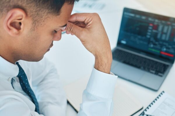 Business man headache and laptop of stock market crash bankruptcy and financial mistake error or wrong statistics Sad stress or fatigue trader on computer screen data or trading with depression