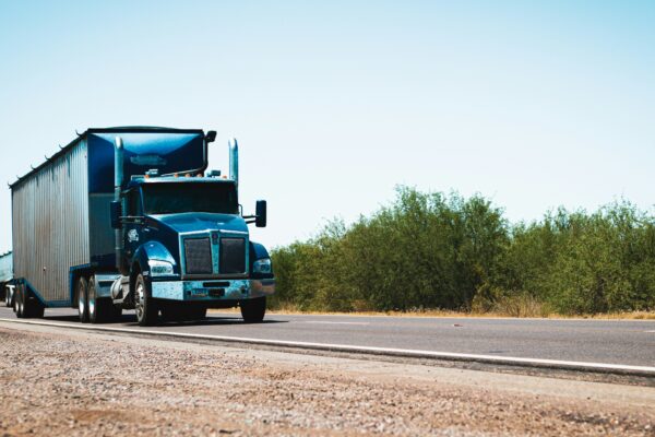 A semi truck driving down the road in the desert