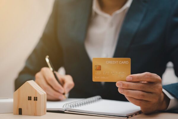 Businessman hand write note on paper with hold credit card with financial transaction with credit card and laptop computer, Online shopping concept, banking and online shopping at the home.