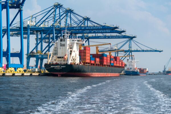 a large cargo ship in the water with a large crane in the background