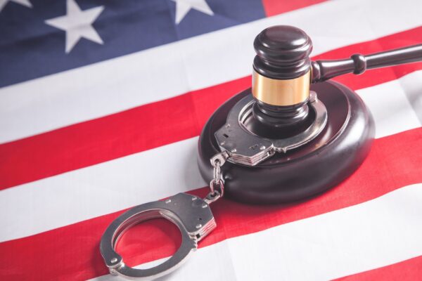 Judge gavel with handcuffs on the Usa flag.