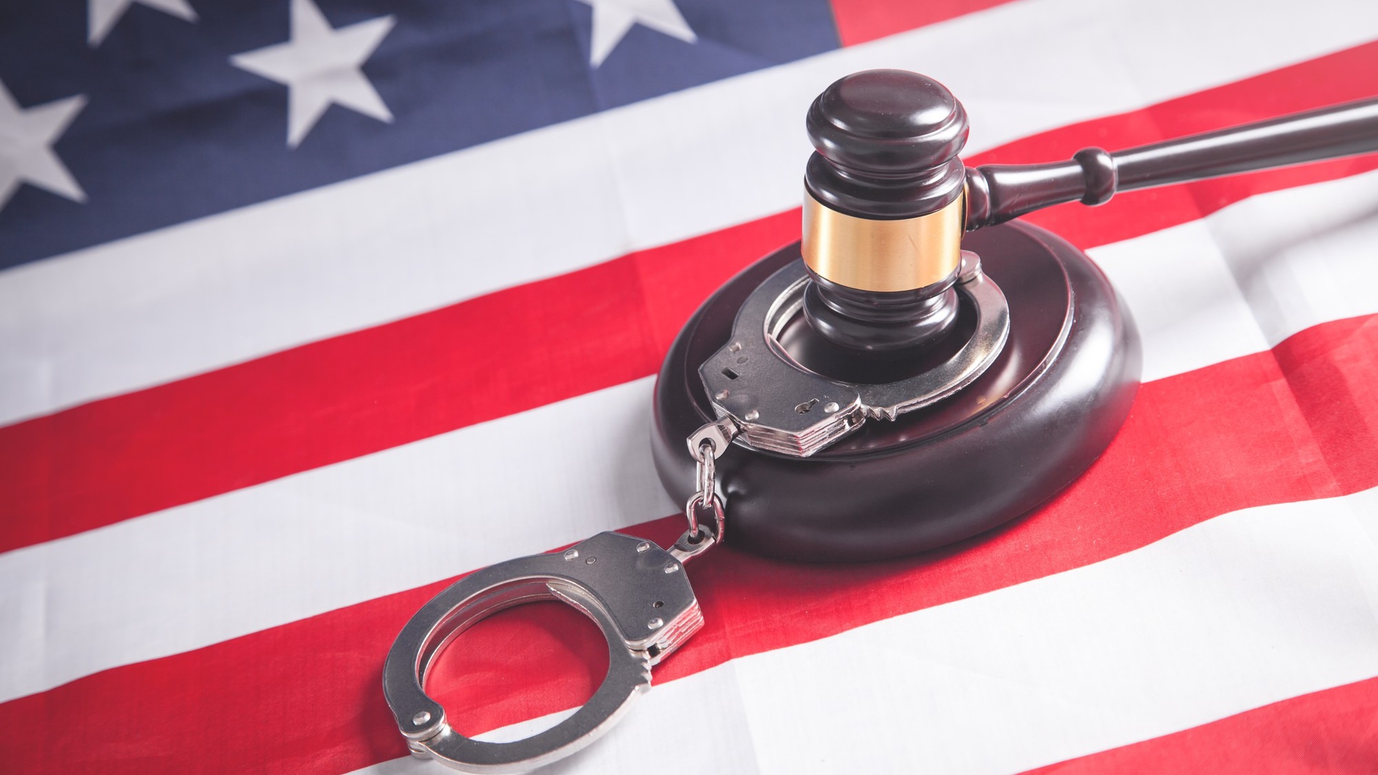 Judge gavel with handcuffs on the Usa flag.