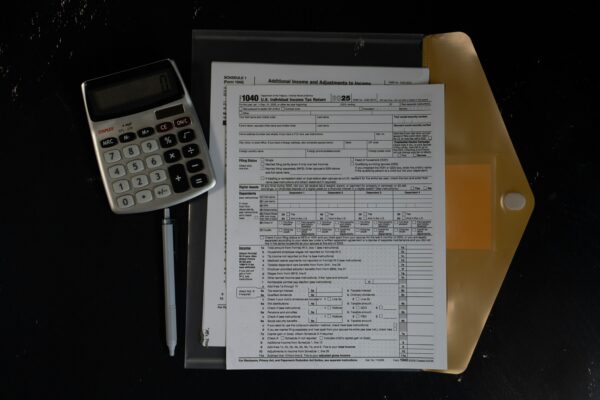 Calculator and papers in a folder on a dark surface