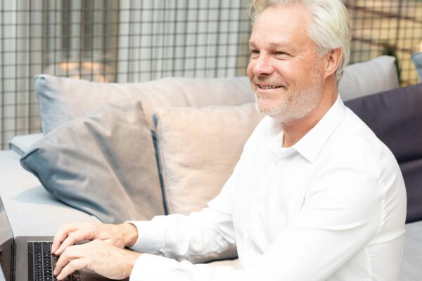 a man sitting on a couch using a laptop