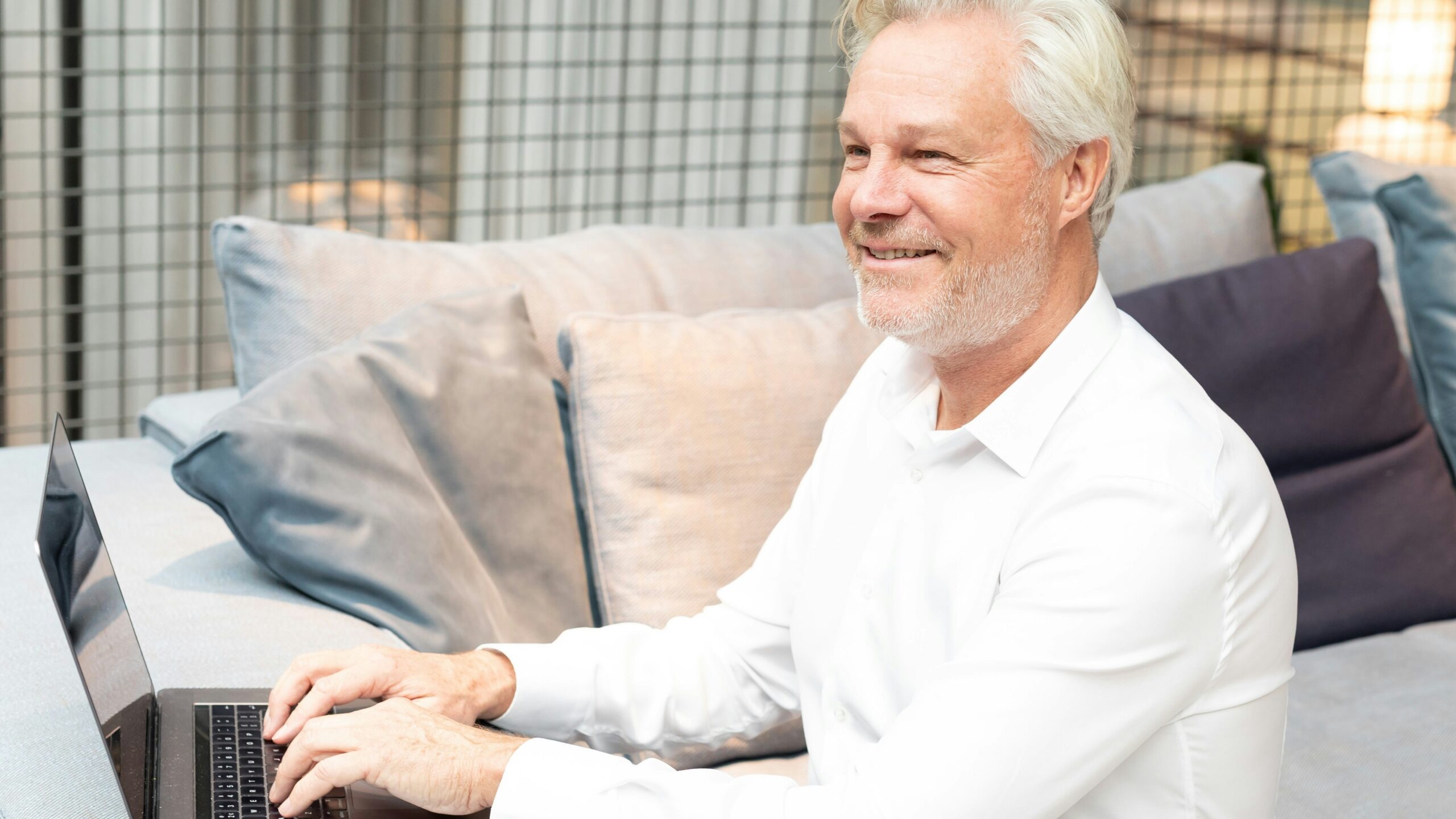 a man sitting on a couch using a laptop