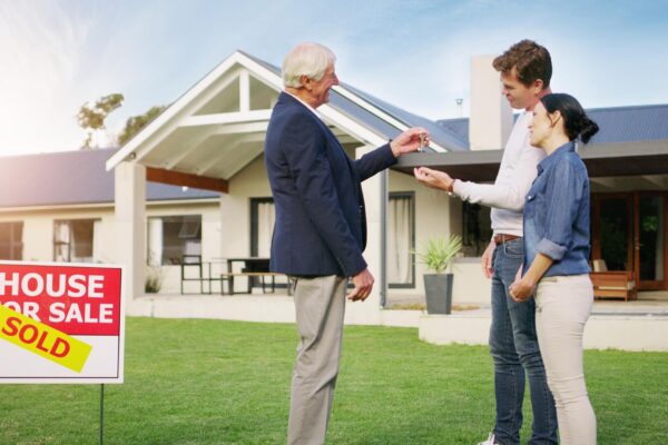 Couple real estate and realtor with keys to new home payment or mortgage loan on lawn outside Happy man and woman in relationship or homeowners with agent for buying property sale or sold house