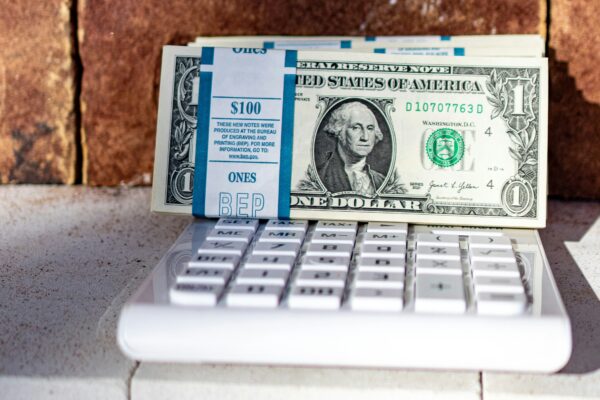 a dollar bill sitting on top of a laptop keyboard