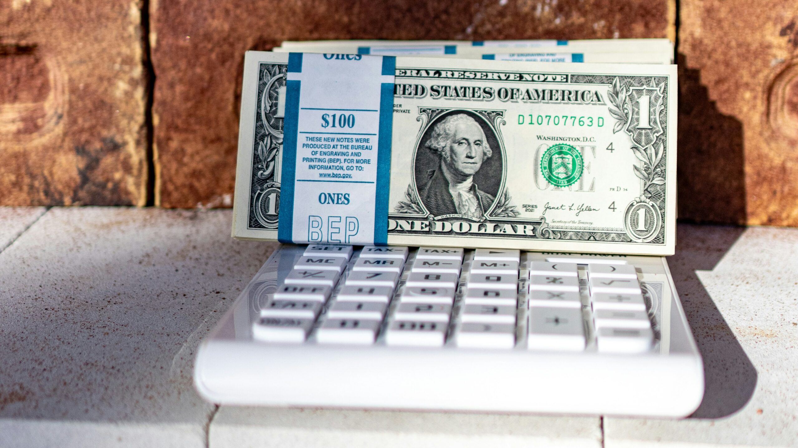 a dollar bill sitting on top of a laptop keyboard