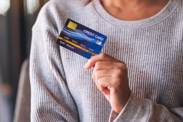 Closeup image of a woman holding and showing credit card