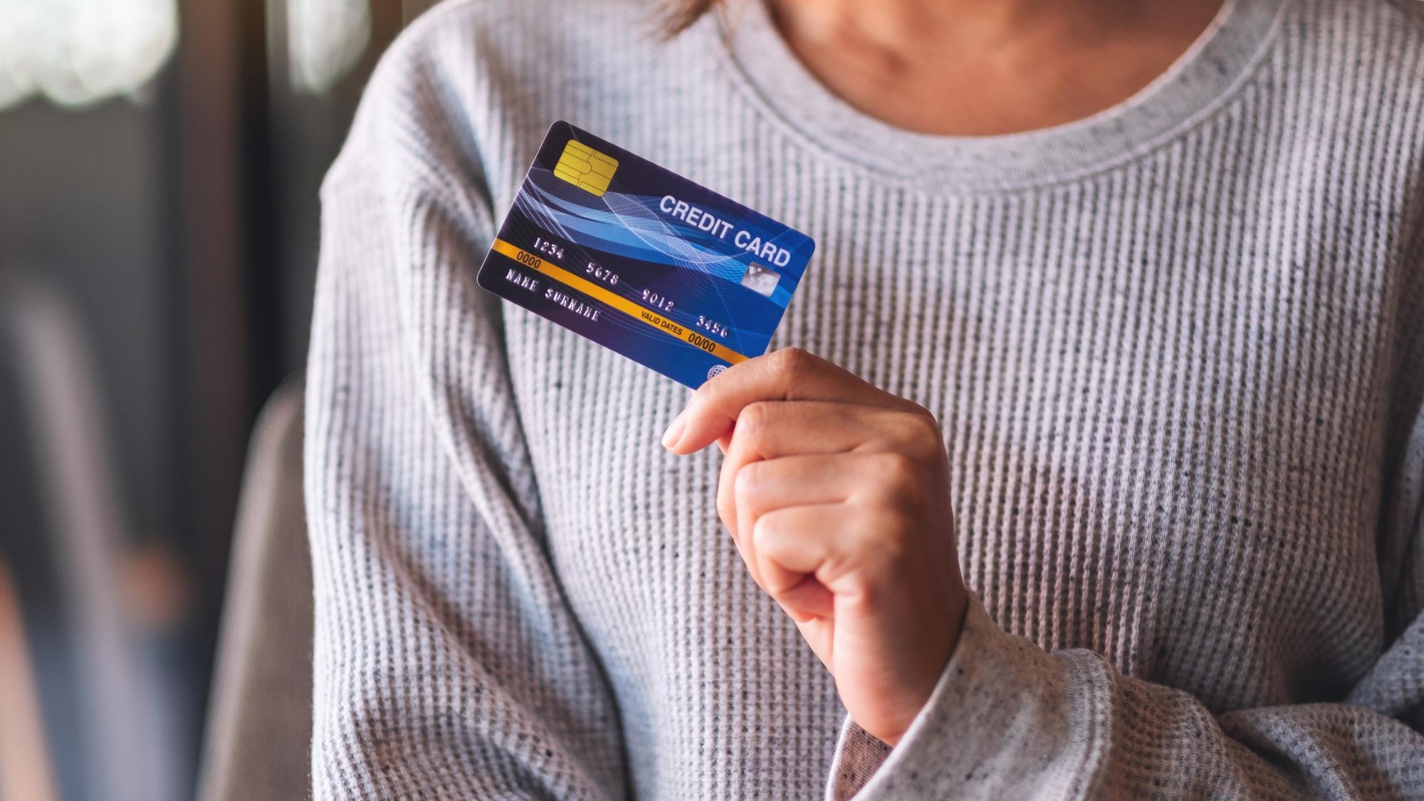 Closeup image of a woman holding and showing credit card