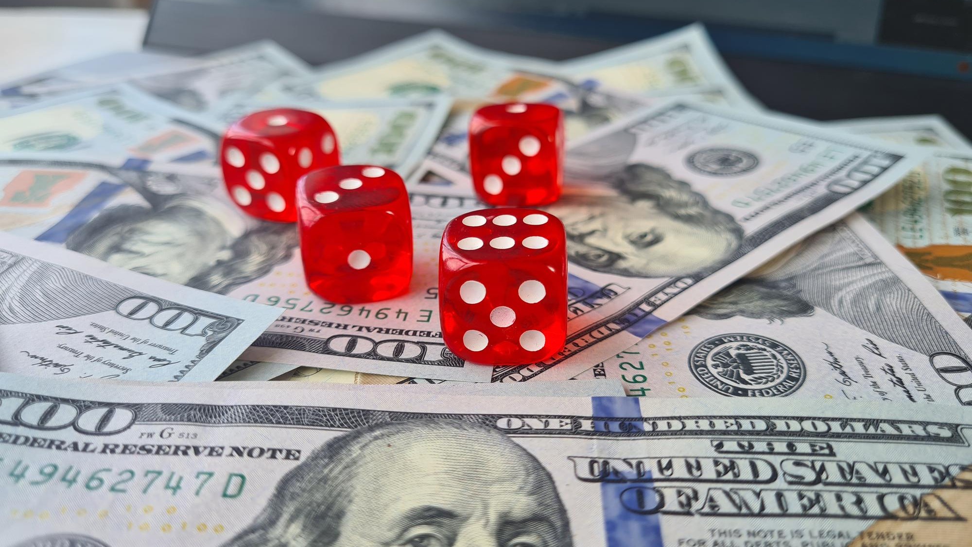 Dice and dollar banknotes on laptop keyboard Online casino and online gambling c