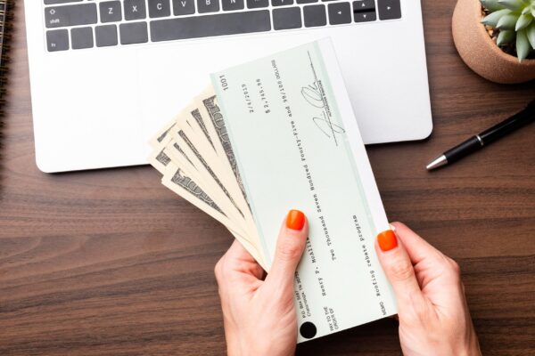 Close up hands holding cash and check