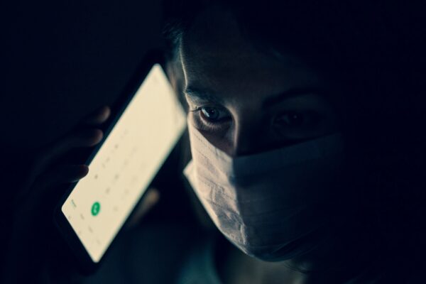 man in white crew neck shirt holding white smartphone