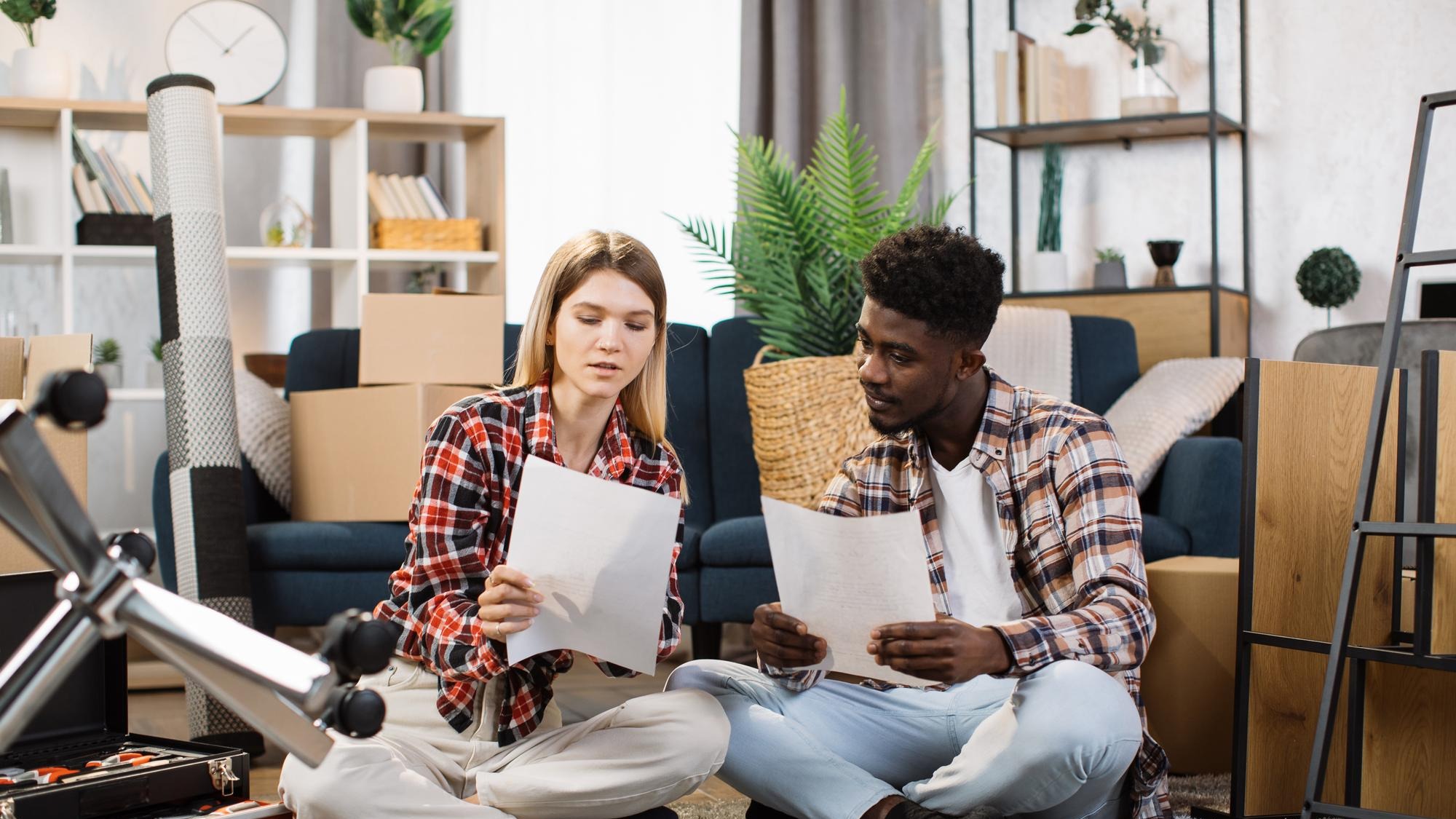 Diverse couple advising about furniture placement at flat