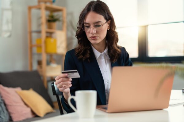 An attractive young business woman making payments while working on her computer in the office