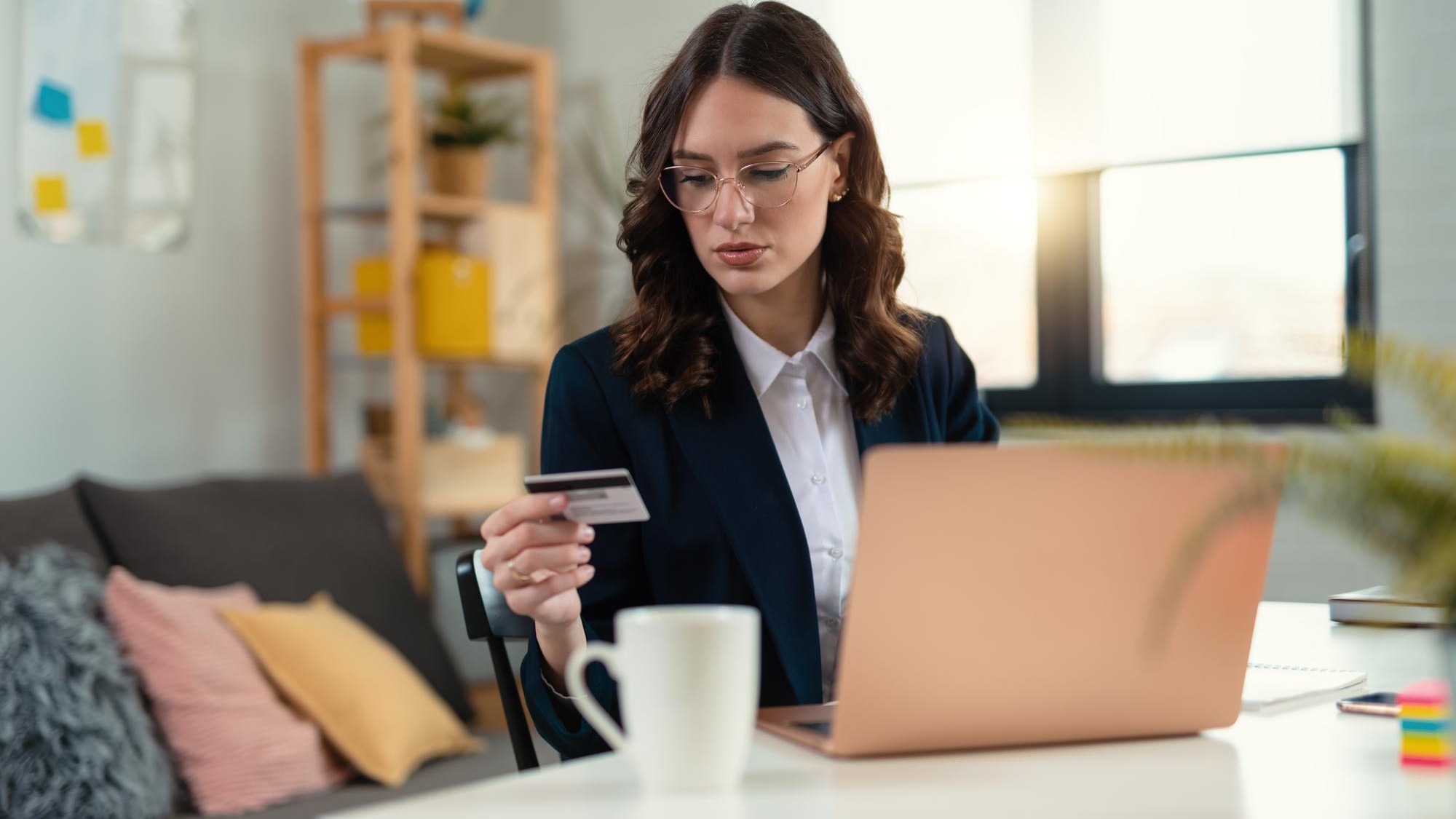An attractive young business woman making payments while working on her computer in the office
