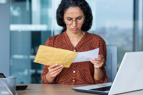 Dissatisfied and upset businesswoman received letter in envelope depressed latin american