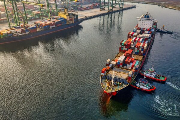 red and blue cargo ship on body of water during daytime