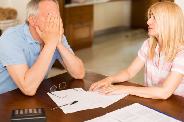Worried couple calculating their expenses together