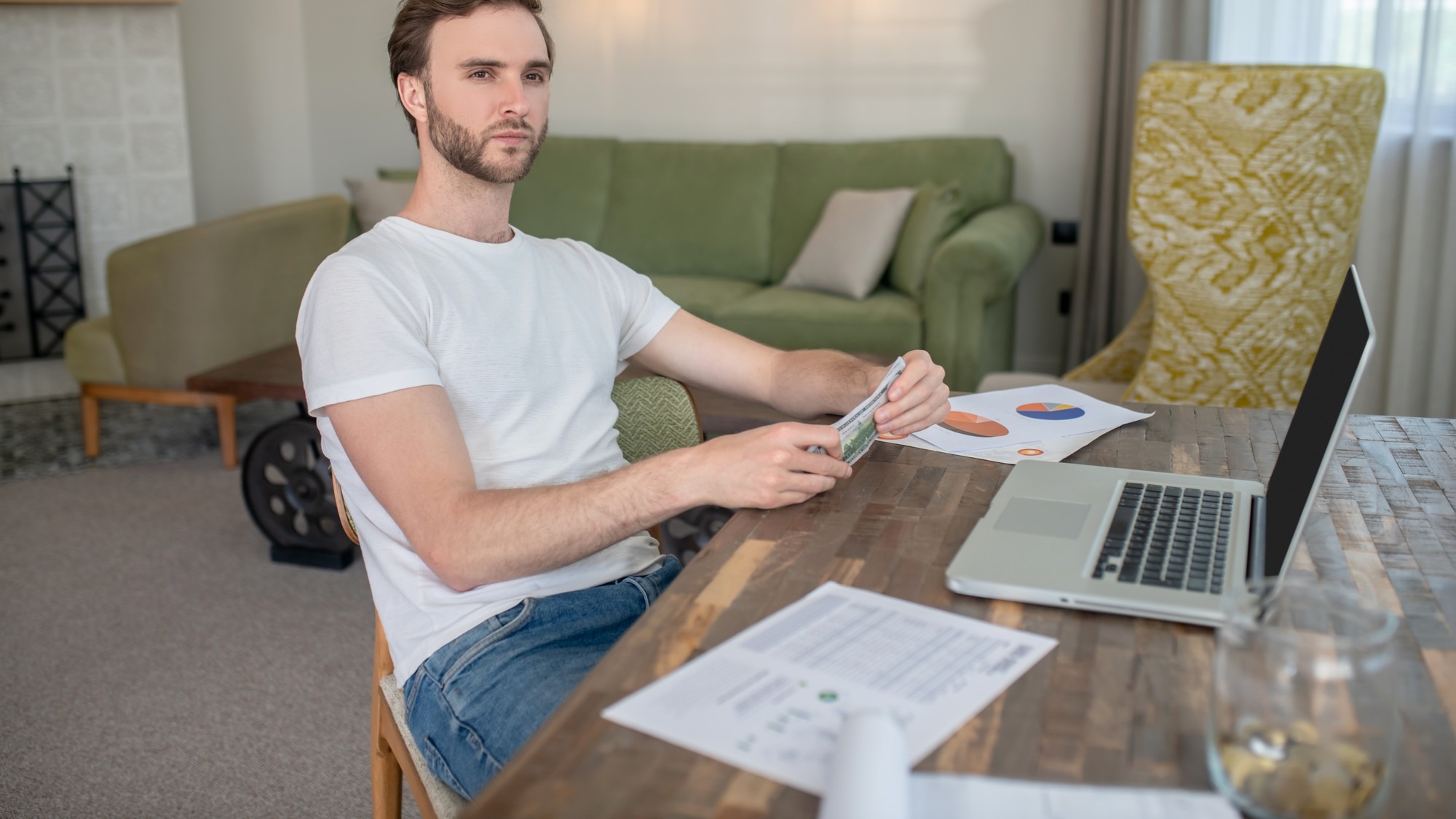 Young bearded man working on a laptop and looking concentrated
