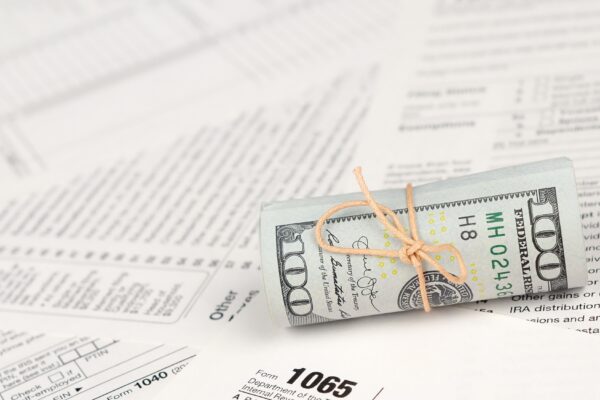 1065 U.S. Return of Parentship Income form with roll of american dollar banknotes