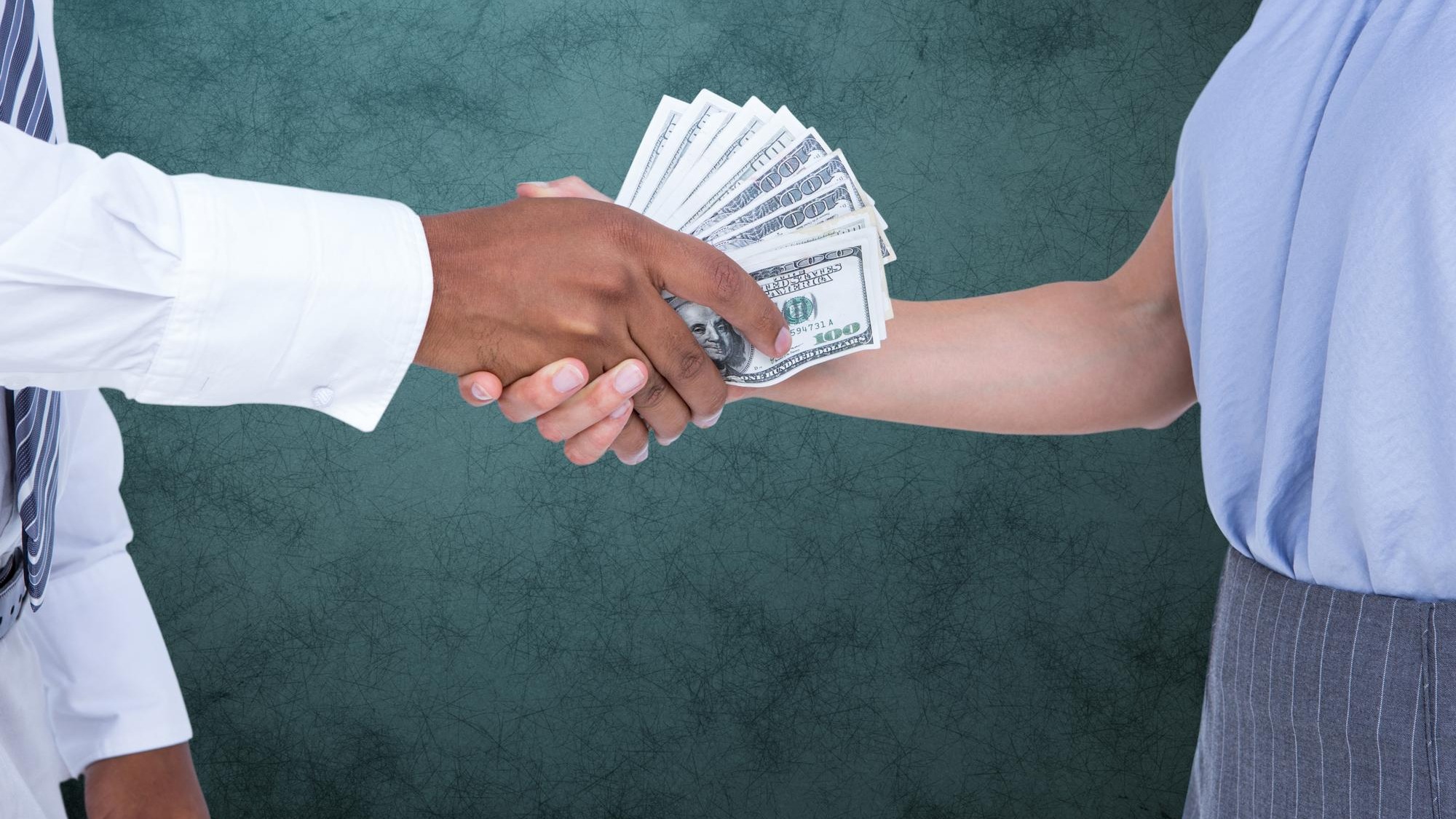 Businessman bribing partner while shaking handsA against teal background