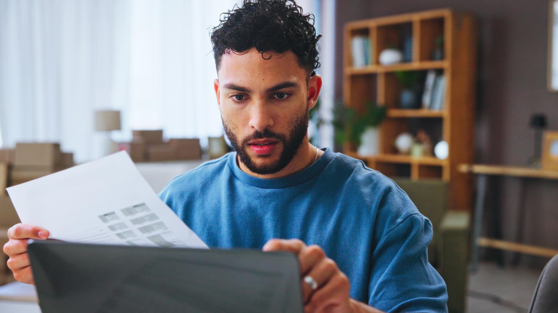 Small business review and man with documents laptop and confused by financial report and online Reading entrepreneur and person with paperwork for taxes boxes and planning for audit or serious