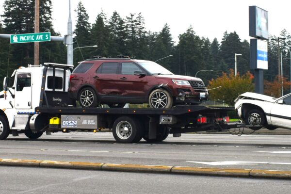 A tow truck towing a car on a flatbed
