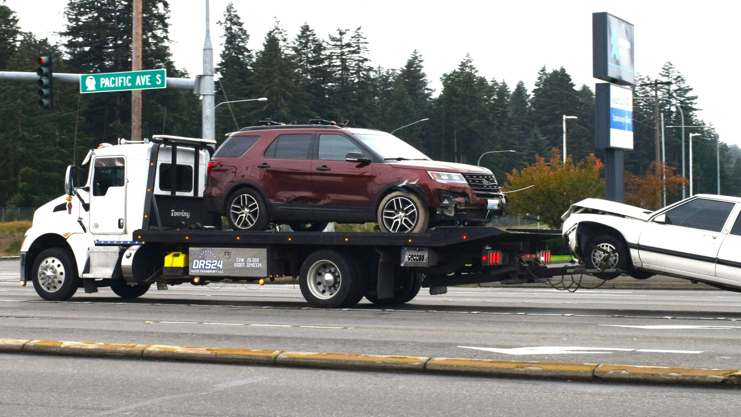A tow truck towing a car on a flatbed