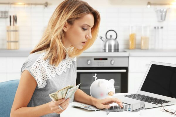 Woman counting taxes at table indoors