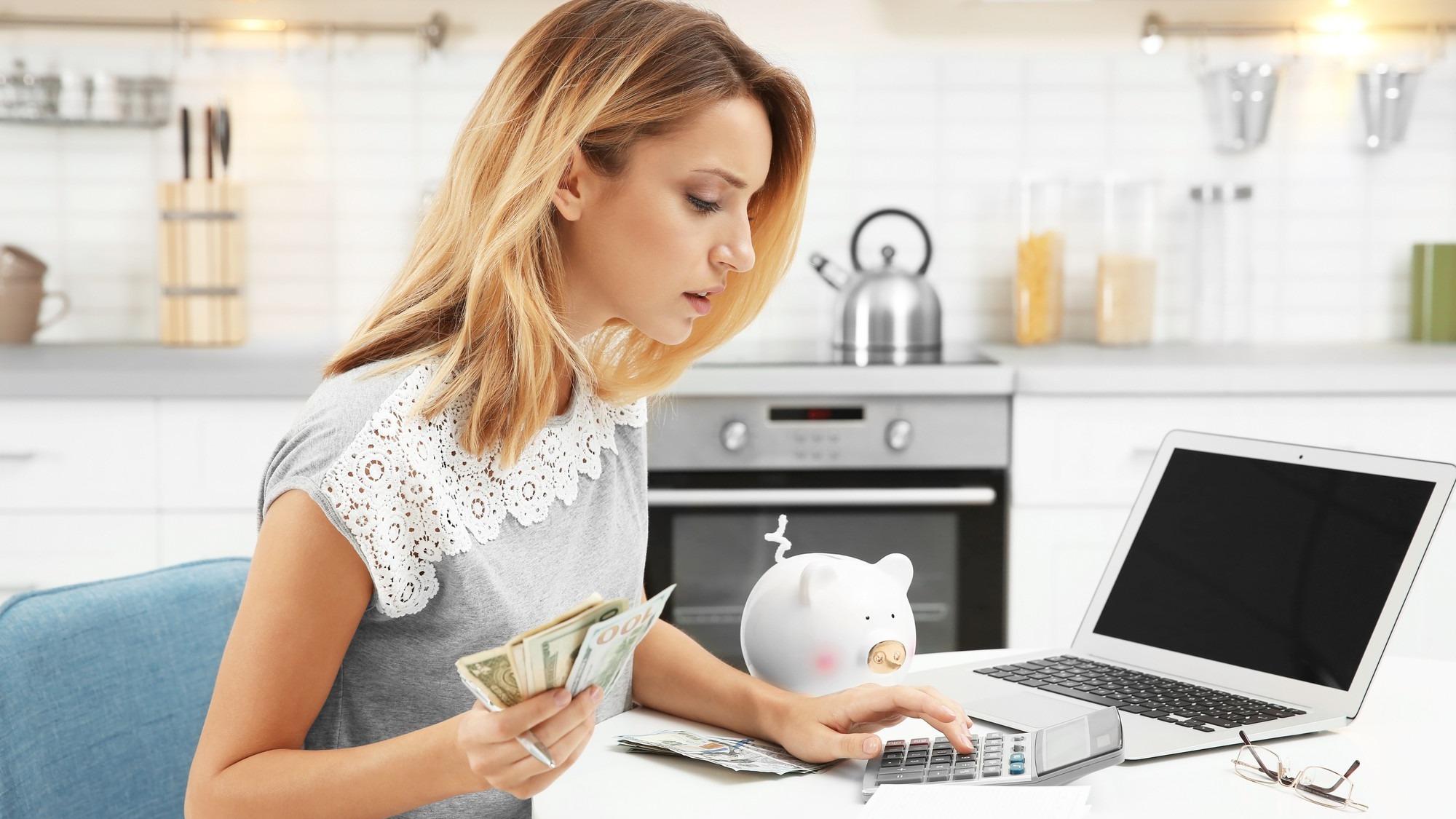 Woman counting taxes at table indoors
