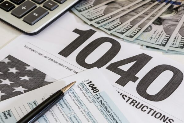 tax forms 1040 and calculator with dollars