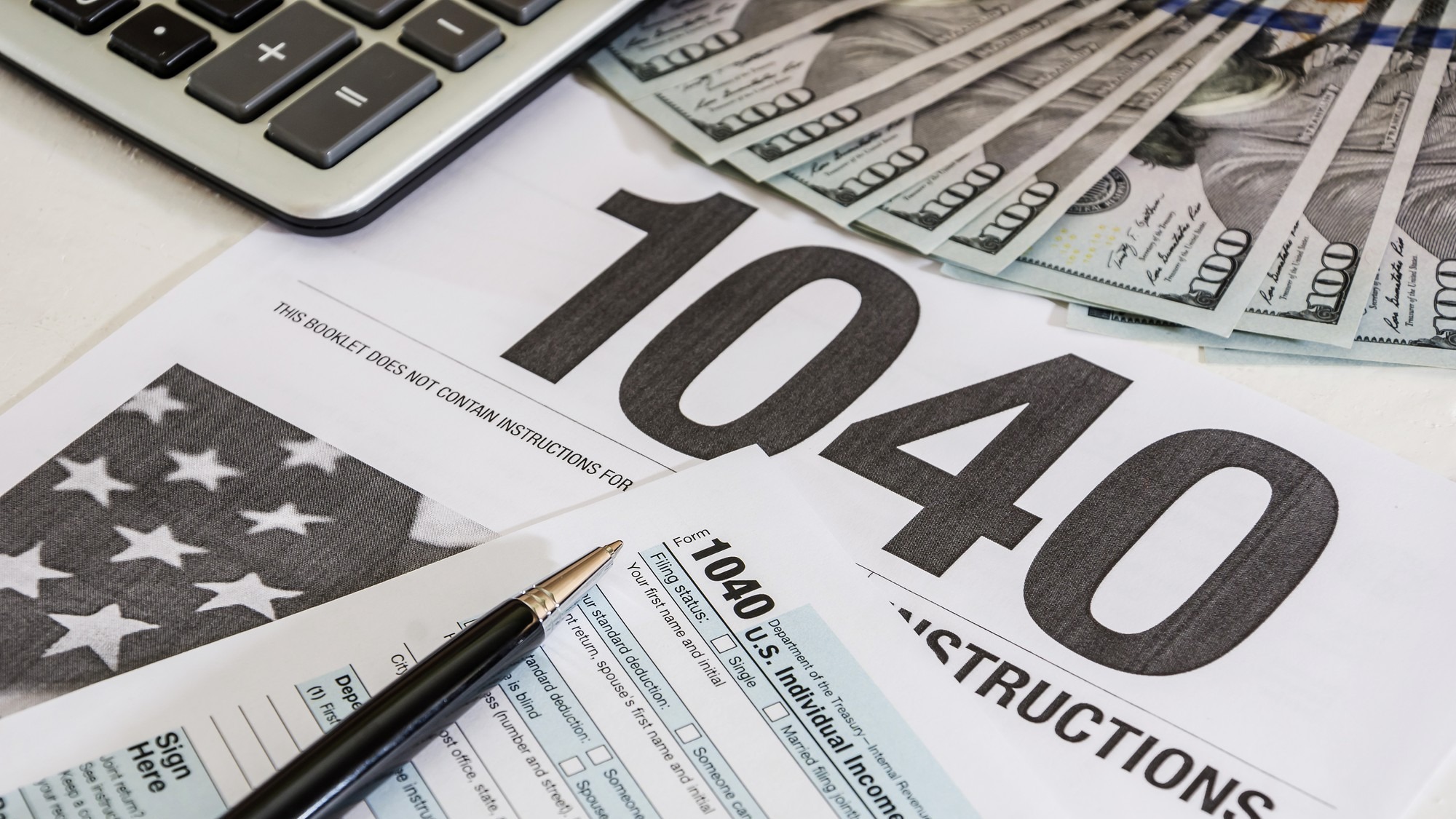 tax forms 1040 and calculator with dollars