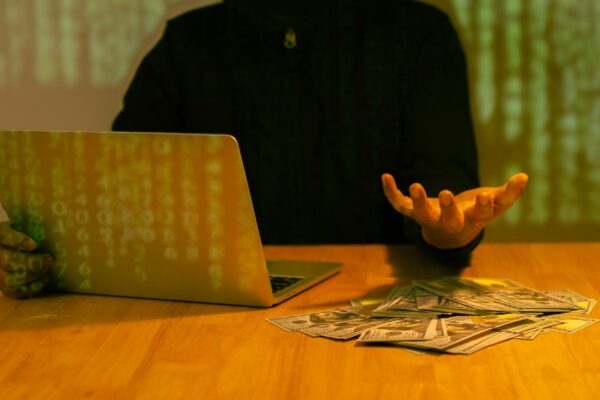 Hacker wearing black hooded with laptop hacking and stealing big data and finance information