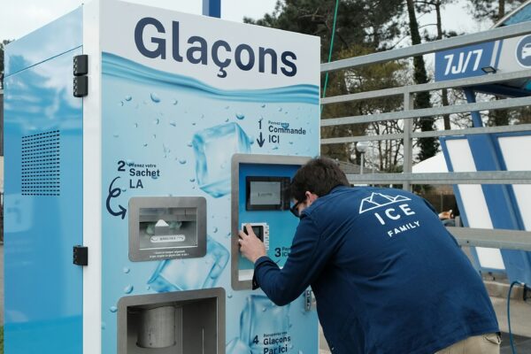 A man is operating an ice vending machine.